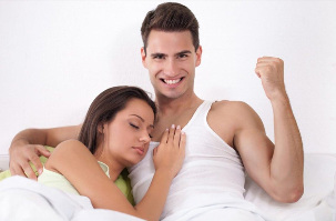 Strong man in bed with a girl